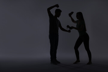 Domestic violence. Silhouette of man threatening his wife on grey background