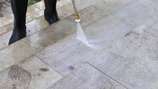 Cleaning service employee washing stone steps