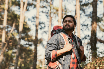 Obraz premium Travelers hiking through a forest with backpacks, exploring the wilderness and taking in the sights of nature as they walk.