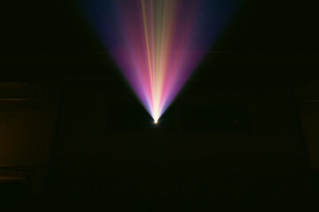 view of a colorful light beam in a dark room 