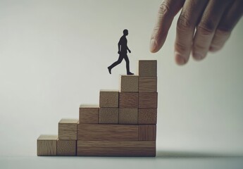 Hand walking on wooden block stairs with human silhouette, a growth concept for business development and personal achievement in a stock photo. A man's hand walks up the steps of wooden blocks to a su