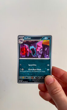 Hamburg, Germany - 12232024: male hand holding the English pokemon paper tradingcard called GOLBAT from the Shrouded Fable set. 