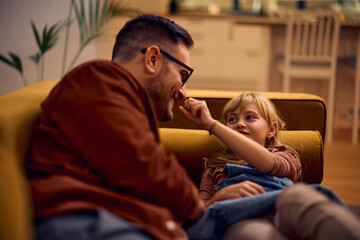 Fototapeta premium Happy father and daughter having fun while relaxing in living room.