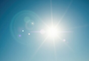 A bright sun shines in a clear blue sky.