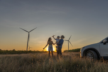 Family with son walking on field on wind farm. Happy Family and son playing at the Wind turbines...
