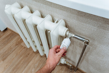 Adjusting a modern thermostat that is connected to a white radiator is crucial for achieving...