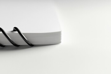 close-up of a spiral bound notepad with blank white pages