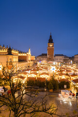 Fototapeta premium View of the Krakow Christmas Market 2024 and the historic Old Town Square, beautifully illuminated with festive lights and vibrant holiday atmosphere.