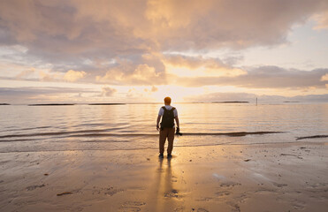 Naklejka premium A Serene and Beautiful Sunset at the Beach with a Person Gently Gazing into the Distant Horizon
