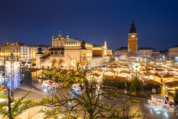 Fototapeta premium View of the Krakow Christmas Market 2024 and the historic Old Town Square, beautifully illuminated with festive lights and vibrant holiday atmosphere.
