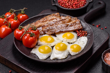A hearty, delicious breakfast with fried eggs, bacon and tomatoes