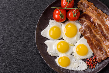 A hearty, delicious breakfast with fried eggs, bacon and tomatoes