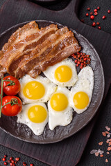 A hearty, delicious breakfast with fried eggs, bacon and tomatoes