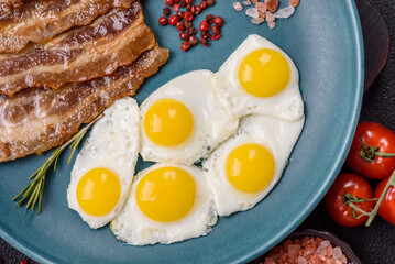 A hearty, delicious breakfast with fried eggs, bacon and tomatoes