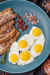 A hearty, delicious breakfast with fried eggs, bacon and tomatoes