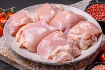 Fresh raw chicken thigh fillets with salt, spices and herbs