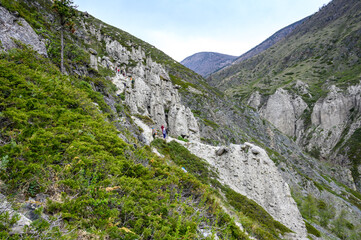 Stone formations on the slope of a high mountain under a clear summer sky. Stone mushrooms, Altai.