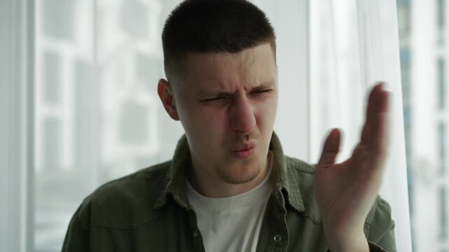 The man gestures that it stinks very strongly.
The stench is strong and the man feels sick.
A man covers his nose from the strong stench.
Someone spoiled the air