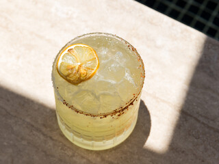 Close up of a Mezcal Margarita in a pool setting 
