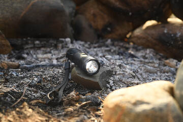 Chargeable flashlight and electric lighter for outdoor adventures in nature showing practical utility for campers and hikers