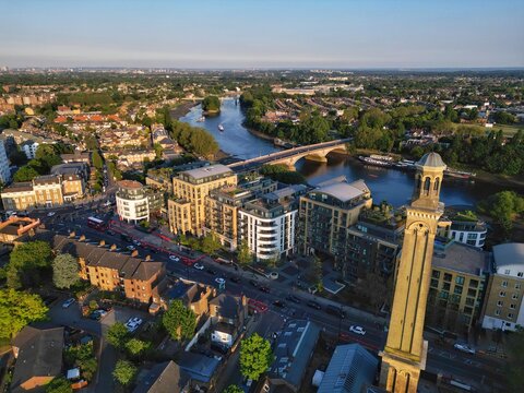 Aerial drone view of Kew Bridge over river Thames and a steam brick tower in Brentford, London, England, on a sunny summer day 