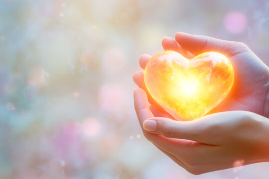 Glowing heart in female hands signifying love and warmth