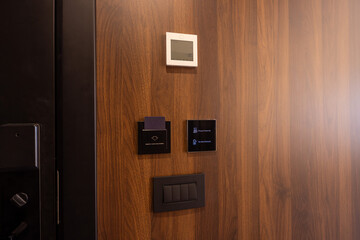 Electronic door access and climate control on wooden hotel room wall