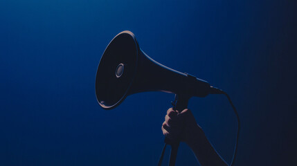 photo of hand holding a megaphone in studio background, the backdrop