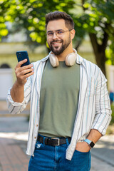Happy successful satisfied Caucasian man young guy male traveler mobile phone user holding...