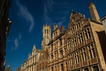 Fototapeta premium Top places to visit in Belgium : Bruges historic city. Outstanding belfry and buildings architecture in main shopping street. 
