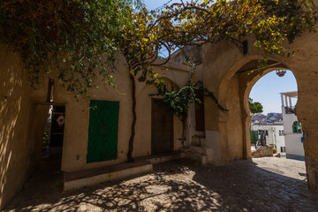 Fototapeta premium narrow alleyway leading to a hidden courtyard with a stone archw