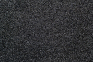 Black wool texture: A close-up of smooth wool fabric in a deep black color. Black wool fabric. The uniform texture conveys sophistication and elegance.