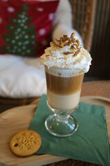 a cup of cappuccino with cream on the background of a Christmas tree