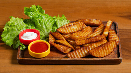 Fries on wooden tray with ketchup and mayonnaise