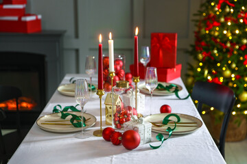 Christmas place setting with festive decor on table in room