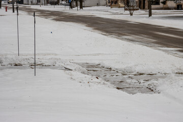 A plowed residential sidewalk in town during the winter.