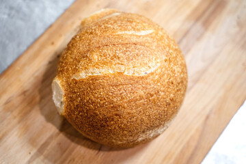Round homemade bread on wooden cutting board