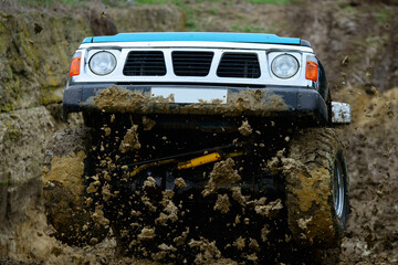 Off-Road Rally Action: 4x4 SUV Jumping Through Deep Mud. Extreme Sports Frontal View © Stefan