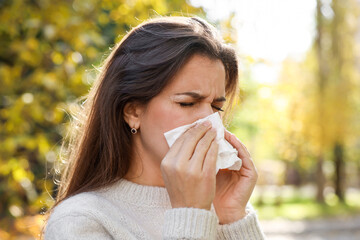 Young woman with runny nose in park