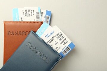 Passports with tickets on light background, top view. Space for text