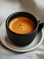Coffee served in a black cup on a white saucer