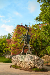A green copper sculpture of a fire-breathing dragon in the ancient Wawel Castle in the center of the European city of Krakow.