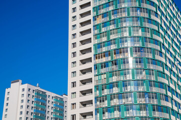 Fototapeta premium Modern newly built residential towers with glass balconies and sleek architectural design under a clear blue sky