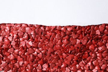 Torn paper with space for text on heart shaped sprinkles, top view