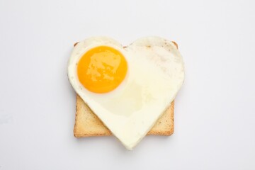 Tasty fried egg in shape of heart with toast isolated on white, top view