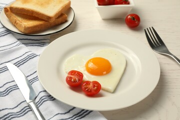 Heart shaped fried egg served on white wooden table