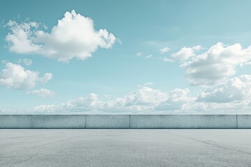 Empty concrete rooftop with blue sky and clouds.