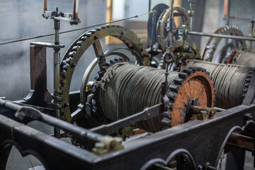 A close-up of an old industrial machine with gears and cables, showcasing intricate mechanical...