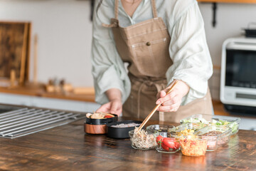 キッチンでお弁当を作る女性の手元
