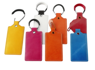 a set of six colorful leather keychains with metal rings. arranged in a semi-circle on a transparent background the keychains are all rectangular in shape and have stitched edges they are all blank. a